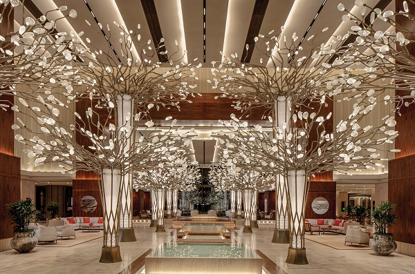 Beautiful tree theme based light setting is arranged in a hotel reception area. 